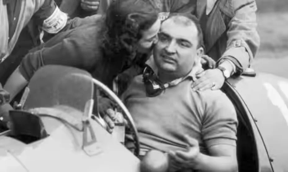 José Froilán González otrzymuje gratulacyjnego buziaka po zwycięstwie w Grand Prix Wielkiej Brytanii 1951 w swoim Ferrari.